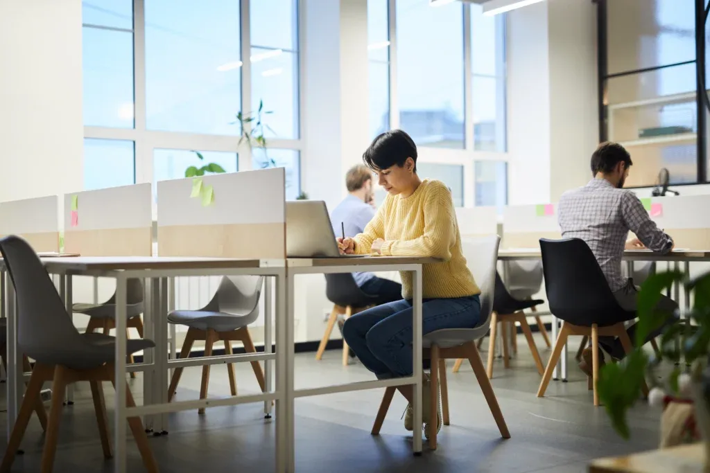 Mesa compartilhada em coworking com profissionais trabalhando